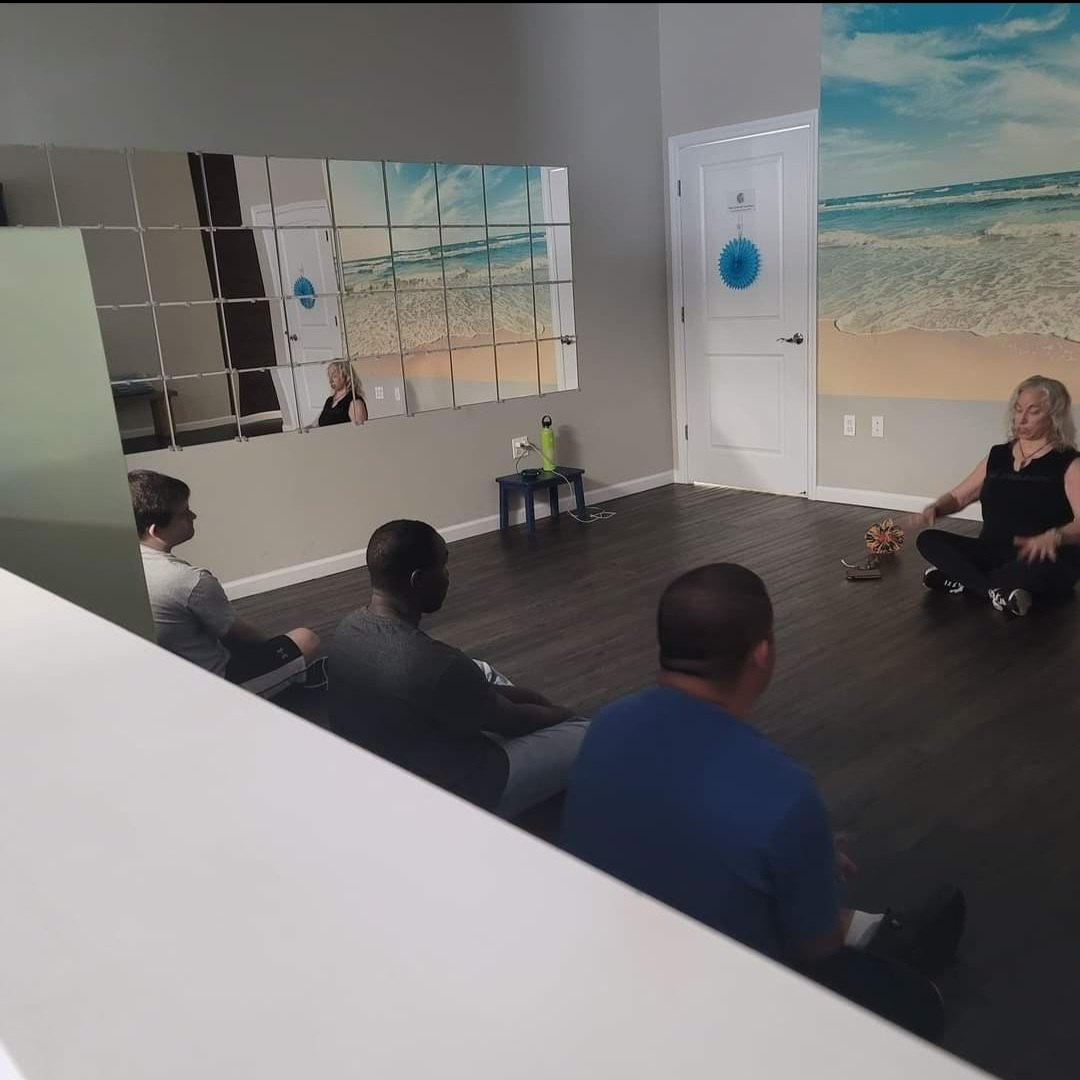 A small group seated in a circle during a mindfulness session